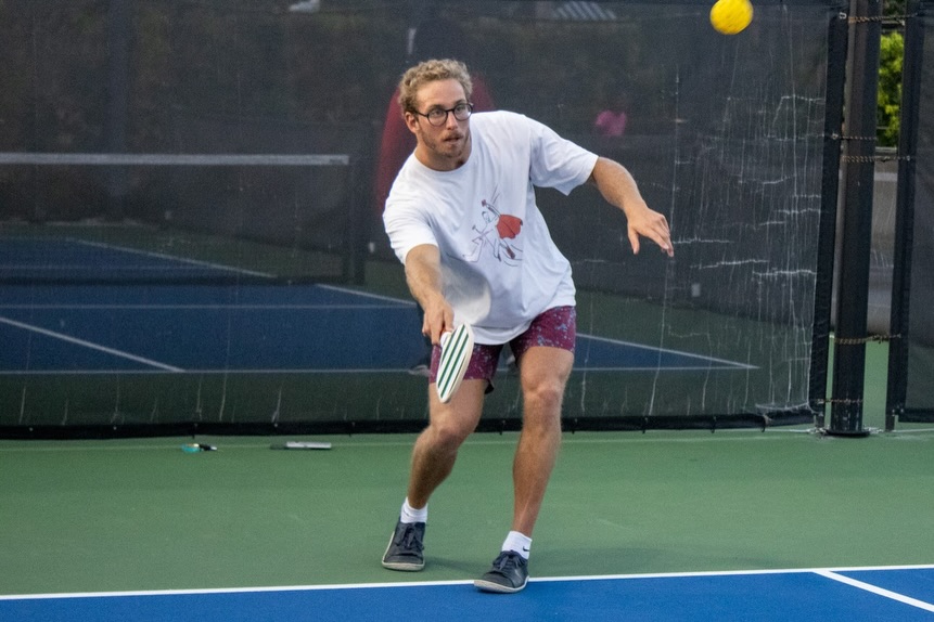 A member returning a shot during evening open play in Nassau